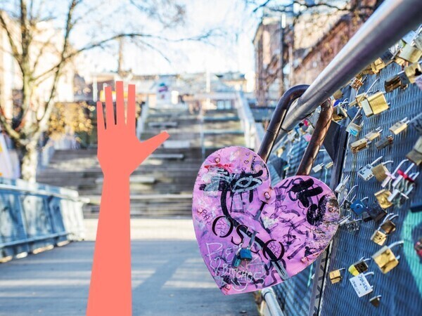 Bilde av en stor hjertelenke på broen over Akerselven mot Kunsthøyskolen. Illustrasjon av en opprakt hånd.