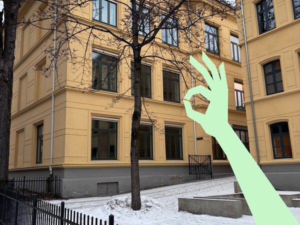 Bildet av inngangspartiet til Møllergata skole på vinteren, med illustrasjon av hånd som viser "OK".